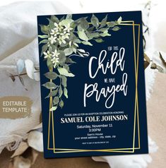 an elegant navy blue and gold wedding card with greenery on the front is shown