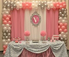 a table with balloons, cake and other items on it in front of a backdrop