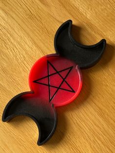 a red and black object sitting on top of a wooden table