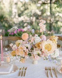 the table is set with flowers and candles