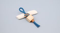 a wooden block tied to a blue rope with a knot on it and a white piece of wood in the middle