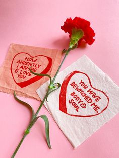 two valentine's day napkins with red flowers on pink background