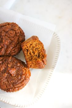 three muffins sitting on top of a white paper plate