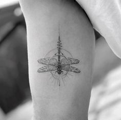 a black and white photo of a dragonfly tattoo