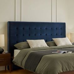 a blue headboard on a bed in a room with wood floors and white walls