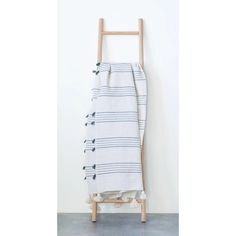 a towel hanging on a wooden rack against a white wall with a black and grey striped design