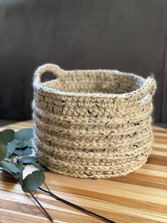 a crocheted basket sitting on top of a wooden table