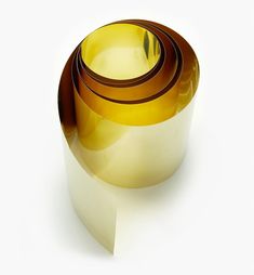 three rolls of gold colored tape sitting on top of each other in front of a white background