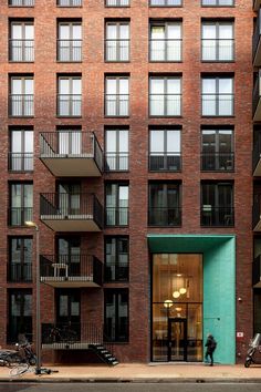 an apartment building with several balconies and bicycles parked on the sidewalk in front