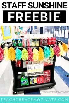 a shelf with soda cans and pom poms on it, in the middle of a classroom