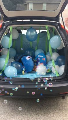 an open hatchback car with balloons and streamers in the trunk