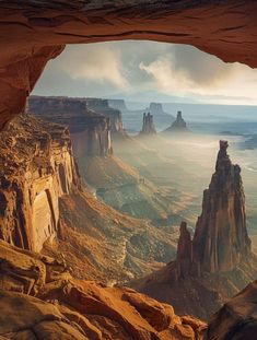 the view from inside a cave looking down at mountains and cliffs in the distance,