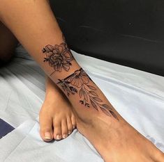 a woman's foot with a flower tattoo on her left side and the bottom part of her leg