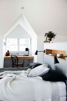 a bed sitting under a window next to a desk