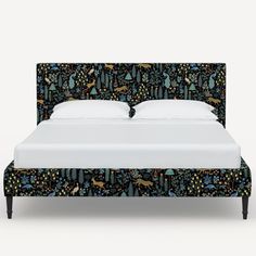 a bed with an upholstered headboard and night sky wallpaper on it