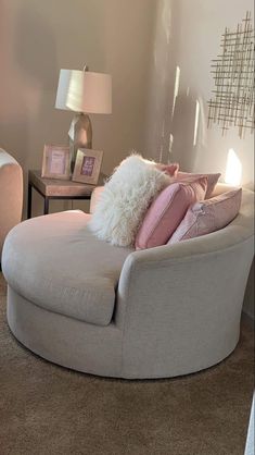 a living room filled with furniture and pillows on top of a chair next to a lamp