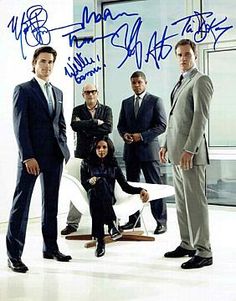 a group of business people standing around each other in front of a window with the city skyline behind them