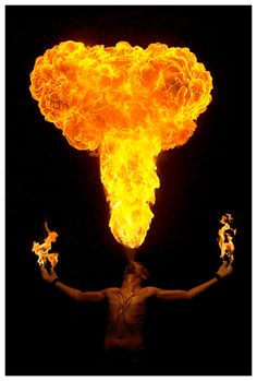 an image of a man with fire coming out of his head and hands in the air