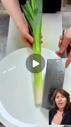 a woman is cutting up a plant with a knife on a white plate and another person is standing behind her