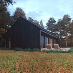 a small black house in the middle of a field with grass and trees around it