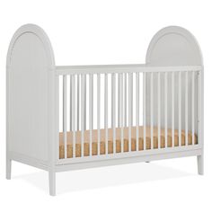 a white crib with a wooden bed frame and mattress in the bottom half, against a white background