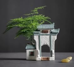 a potted plant sitting on top of a table next to a small white building