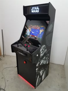 a star wars pinball machine sitting on the floor in front of a white wall