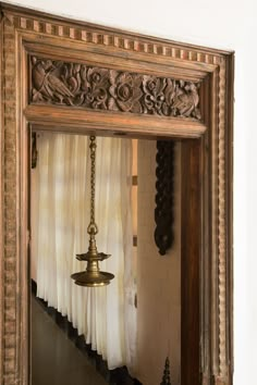 an ornate mirror with a hanging light in it