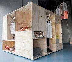 an open wooden box with clothes hanging on it