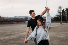 a man and woman holding hands in an empty parking lot