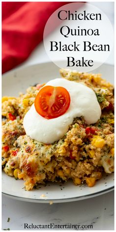 chicken quinoa black bean bake on a white plate with tomatoes and sour cream