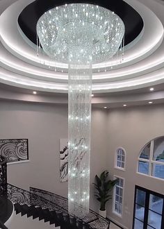 a large chandelier hanging from the ceiling in a living room with black and white decor