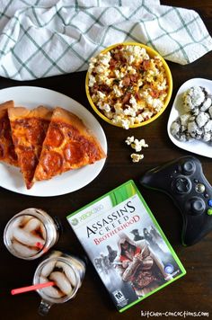 a table topped with pizza, popcorn and other snacks