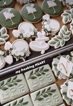 two trays filled with decorated cookies in the shape of animals and flowers, one is green and white