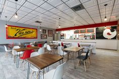 an empty restaurant with tables and chairs in front of a large sign on the wall