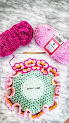 two balls of yarn sitting on top of a table next to knitting needles and crochet hooks