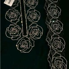 a black dress with white roses on it and a tag hanging from the neckline