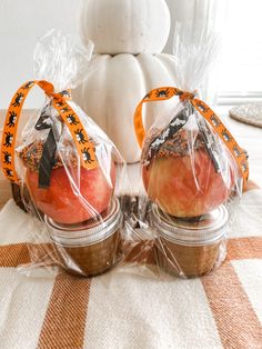 two pumpkins wrapped in plastic and sitting on a table