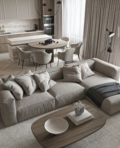 a living room with a large sectional couch and table in the middle, surrounded by chairs