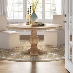 a dining room table with white chairs around it