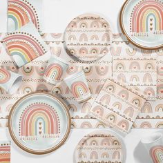 an array of colorful plates and cups on a table with rainbows printed on them