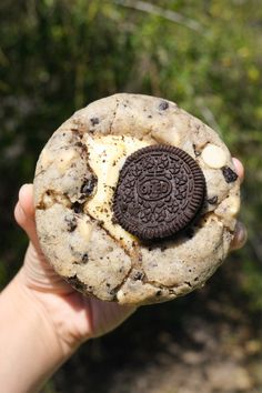 a person holding an oreo cookie in their hand