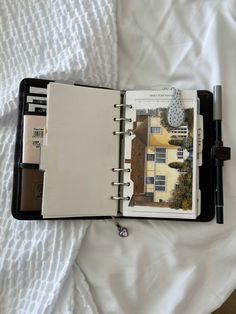 an open planner book sitting on top of a bed