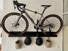 a bike mounted to the side of a wall with two pairs of shoes hanging on it