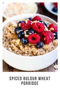 a bowl filled with oatmeal topped with raspberries and blueberries