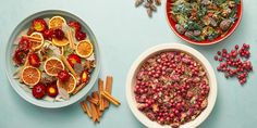 two bowls filled with fruit and nuts next to other food items on a blue surface