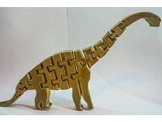 a gold colored dinosaur figurine that is made out of metal and has an intricate design on it