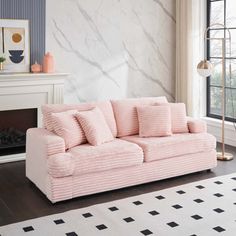 a pink couch sitting in front of a fireplace