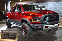 a red ram truck is on display in a showroom