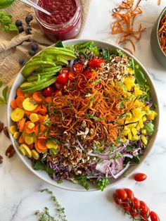 a salad with carrots, lettuce, and other vegetables on a table